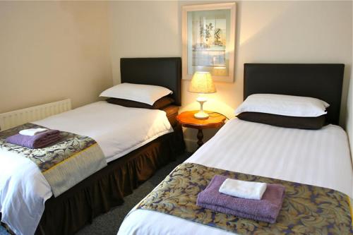 A bed or beds in a room at Melrose Guest House 