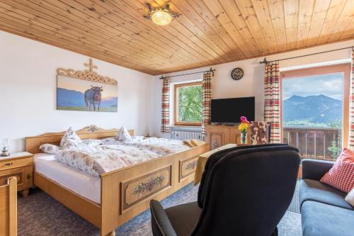 1 dormitorio con cama, sofá y TV en Ferienwohnung Oberrißtraum en Schliersee