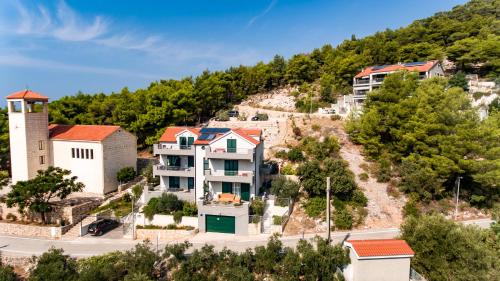 a group of houses on a hill with trees at ISLAND HVAR LUXE Holiday Villa Maslina with Beach in Milna