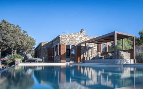 a house with a swimming pool in front of it at Villa Tellus in Stintino