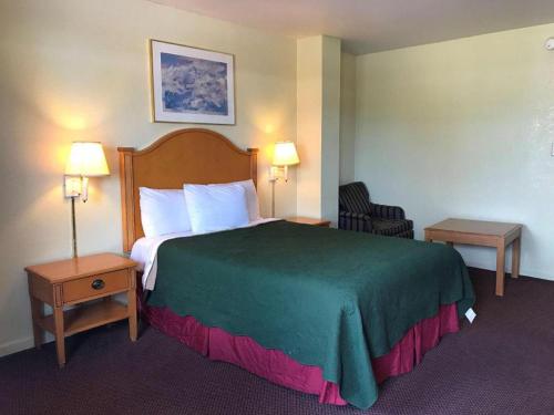 Fairbridge Inn Express - Barrington في Barrington: غرفة فندق بسرير كبير مع بطانية خضراء