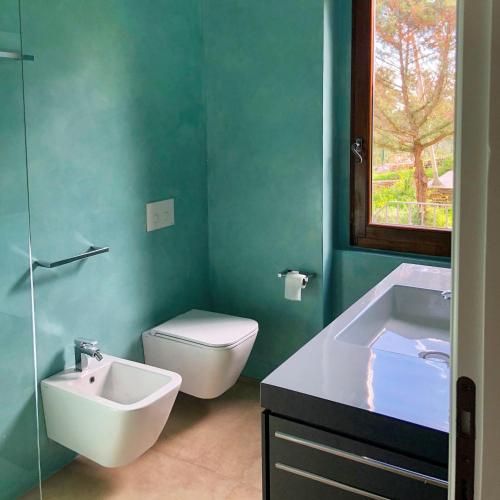 a green bathroom with a sink and a toilet at Villa Tellus in Stintino