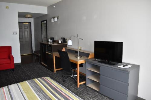 a room with a desk with a television and a desk with a chair at Country Inn & Suites by Radisson, Hagerstown, MD in Hagerstown