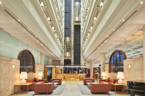 a lobby with chairs and tables in a building at Silken Ciudad de Vitoria in Vitoria-Gasteiz