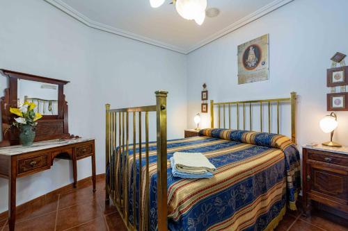 - une chambre avec un lit, une table et un miroir dans l'établissement Casa rural Crisalva, à Granátula de Calatrava
