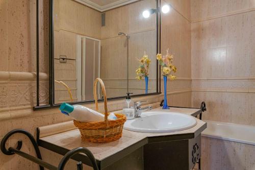 een badkamer met een wastafel en een mand op een aanrecht bij Casa rural Crisalva in Granátula de Calatrava