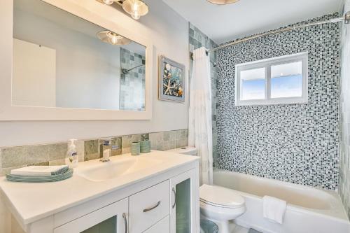 a bathroom with a sink and a toilet and a window at Turtle Beach Retreat in Layton