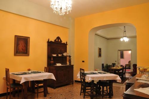 un comedor con 2 mesas y una lámpara de araña en Casa Pagliano, en Noli