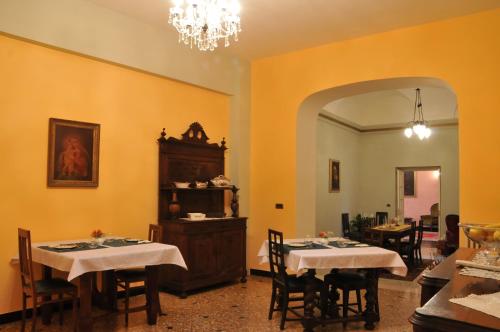 a dining room with two tables and a chandelier at Casa Pagliano in Noli