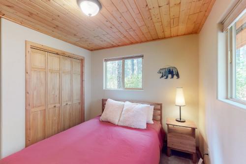 a bedroom with a pink bed and a window at Tivoli Chalet in Leavenworth
