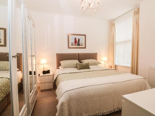 ein Schlafzimmer mit einem großen Bett und einem Kronleuchter in der Unterkunft 2B Cavendish Villas in Buxton