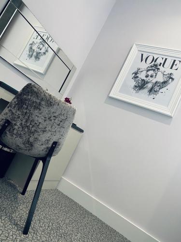 a chair sitting next to a desk with pictures at Dean Park Hotel in Kirkcaldy