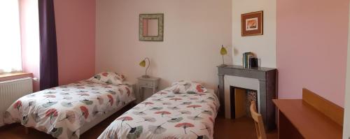 um quarto com 2 camas e uma lareira em Village de Vie em Saint-Vaury