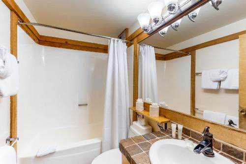 ein Badezimmer mit einem Waschbecken, einem WC und einem Spiegel in der Unterkunft Cozy Condo in Ski Trails in Truckee