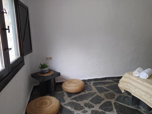 a corner of a room with a table and stools at Hotel Rural La Marmita de Ahlam in Fondón