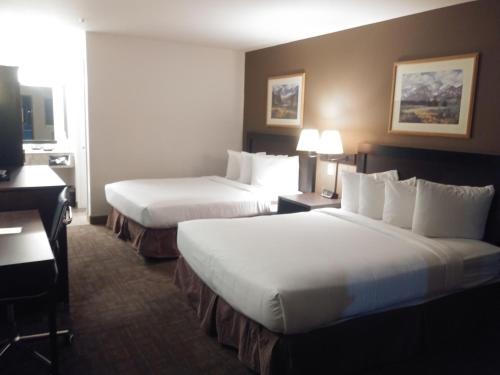 Habitación de hotel con 2 camas y escritorio en Sugarloaf Mountain Motel en Bend