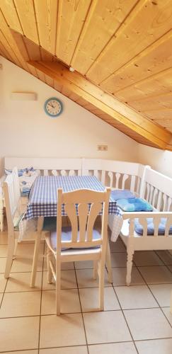 a dining room with a table and chairs and a clock at Haus Marlene in Memmingen