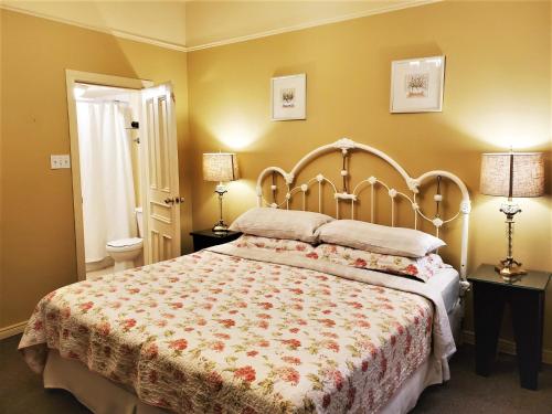 a bedroom with a large bed and two lamps at Abba Inn Guest House in St. John's