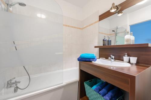 une salle de bain avec un lavabo et une baignoire dans l'établissement Beautiful apartment 8min Disney, à Montévrain