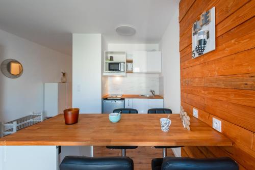 une cuisine et une salle à manger avec une table et des chaises en bois dans l'établissement Beautiful apartment 8min Disney, à Montévrain