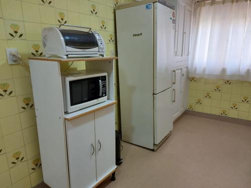 a small kitchen with a microwave and a refrigerator at VILLA VIDA - No se aceptan grupos de jóvenes in Mar del Plata