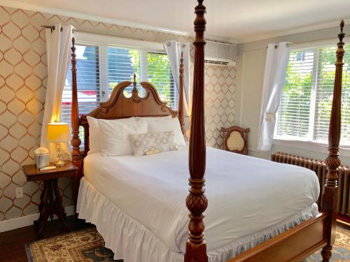 a large bed in a bedroom next to a window at Ivy Manor Inn Village Center in Bar Harbor