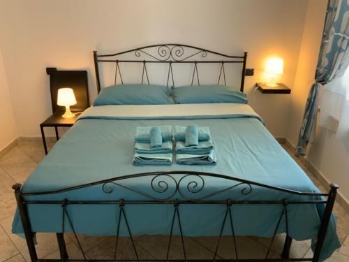 een bed met blauwe lakens en opvouwbare handdoeken bij Parma Holiday 2020+21 in Parma