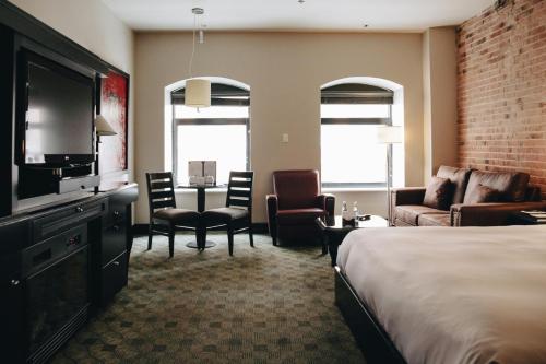 a hotel room with two beds and a television at Hotel Place D'Armes in Montreal