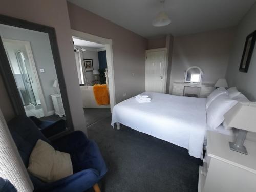 a hotel room with a white bed and a bathroom at Studio D in Doolin