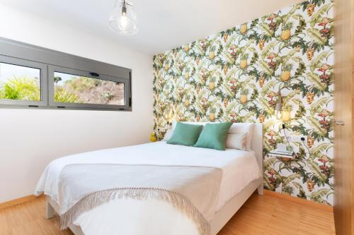 Schlafzimmer mit einem Bett mit Blumentapete in der Unterkunft Apartment with Mount Teide and sea views in Santa Úrsula