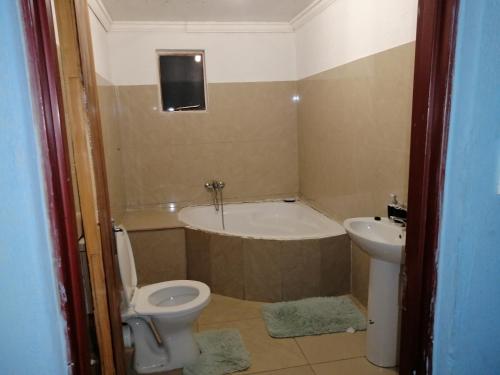 e bagno con vasca, servizi igienici e lavandino. di Moholoholo Lodge ad Acornhoek