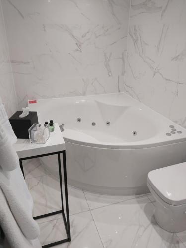 a white bathroom with a tub and a toilet at Dean Park Hotel in Kirkcaldy