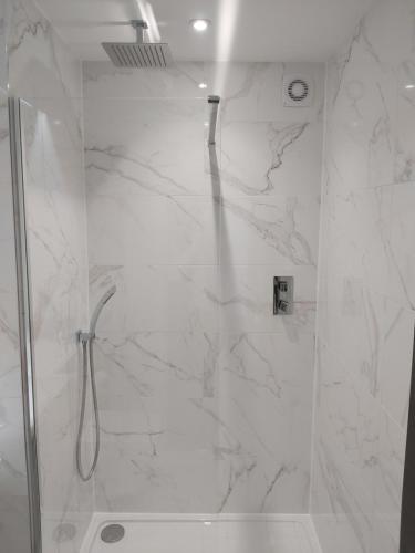 a bathroom with a shower with white marble at Dean Park Hotel in Kirkcaldy