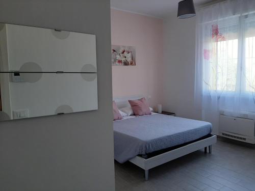 a white bedroom with a bed and a mirror at B&B La Casa di Paolo in Orsogna