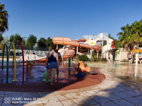 a woman standing in front of a water park at Les sables du midi in Valras-Plage