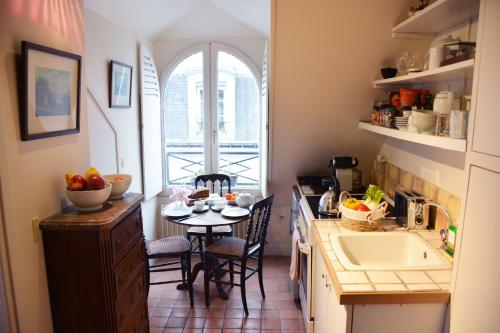 une petite cuisine avec une table et un évier dans l'établissement Charming Studio Near Louvre, à Paris