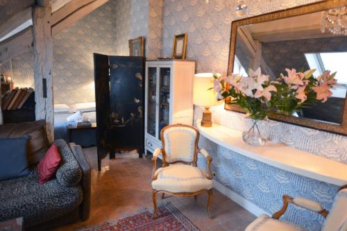 un salon avec une table avec un vase de fleurs dans l'établissement Charming Studio Near Louvre, à Paris