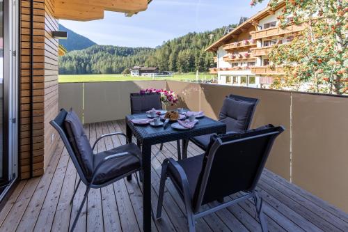 a patio with a table and chairs on a deck at Apart Anemone in Niederthai