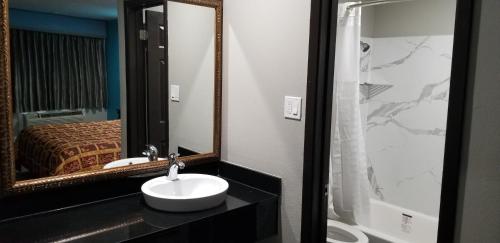 ein Bad mit einem Waschbecken und einem Spiegel in der Unterkunft Delux Inn Mesquite in Mesquite