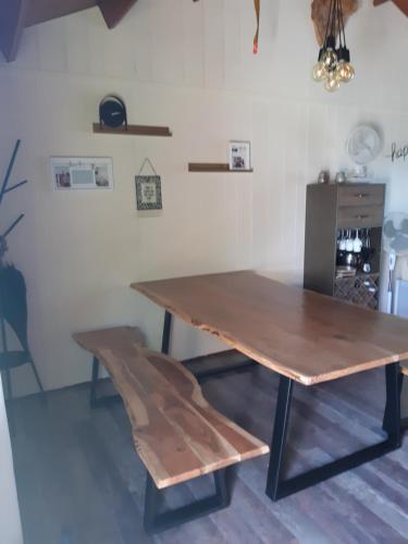 a wooden table and a bench in a room at Into the woods in Rendeux