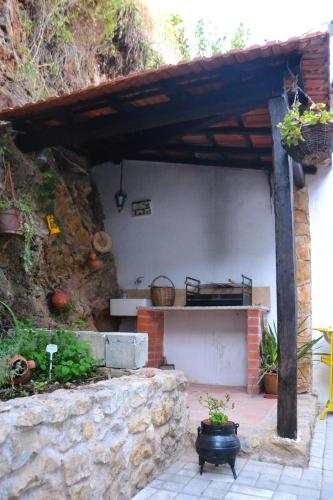 a house with a stone wall and a patio at Casa da Nonô in Coimbra