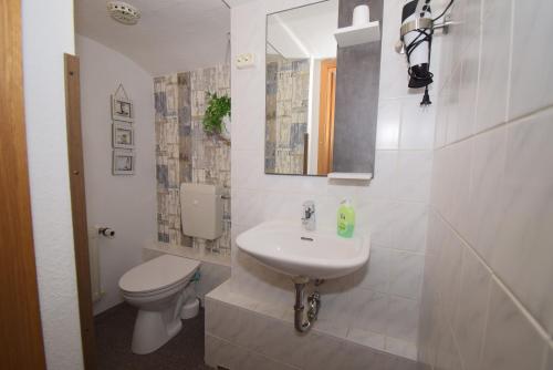 a white bathroom with a toilet and a sink at Villa Margarete in Sassnitz