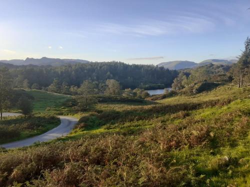 a winding road in the hills near a river at Invergarry Room Only Guest House For Adults in Windermere