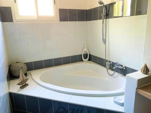 a bath tub in a bathroom with a shower at la maison du bonheur in Saint-Pierre