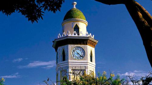 a clock tower with a green top with a clock on it at Holiday Inn Guayaquil Airport by IHG in Guayaquil