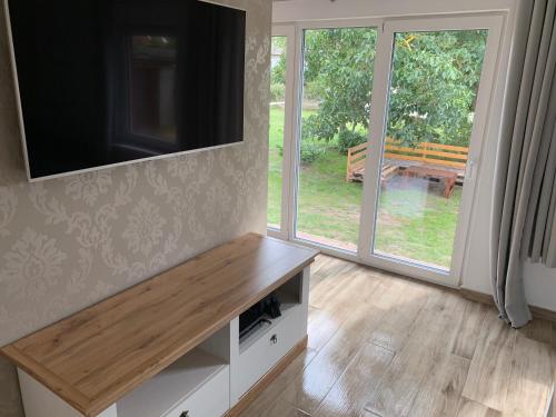a living room with a flat screen tv and a bench at Quartier Usedom in Ostseebad Karlshagen