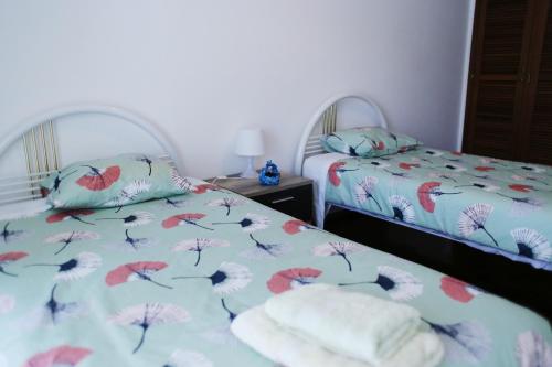 a bedroom with two beds with towels on them at apartamento na praia in Costa da Caparica