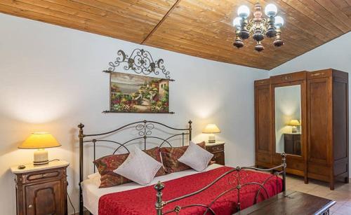 1 dormitorio con 1 cama con manta roja y espejo en Charme of Villa Capannina en Novi Ligure