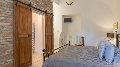 a bedroom with a bed and a brick wall at Charme of Villa Capannina in Novi Ligure