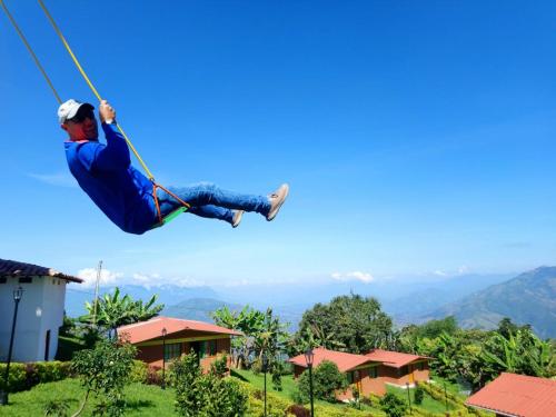 a man on a zip line in the sky at Paraíso Tropical - Hotel Campestre in Aguadas